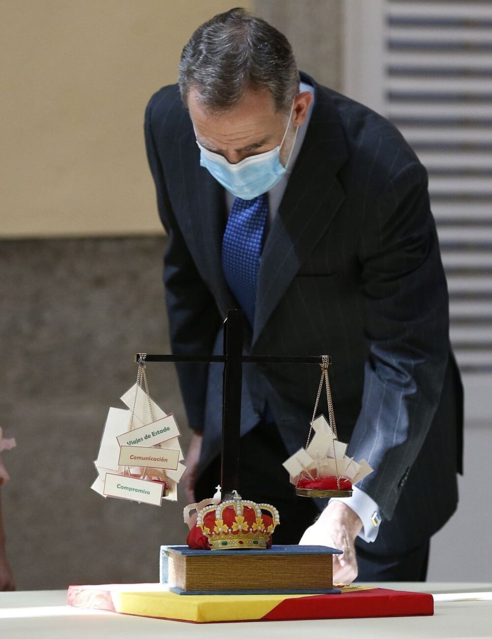 El Rey observa una maqueta con la Constitución y la Corona como garantes de equilibrio en el país.